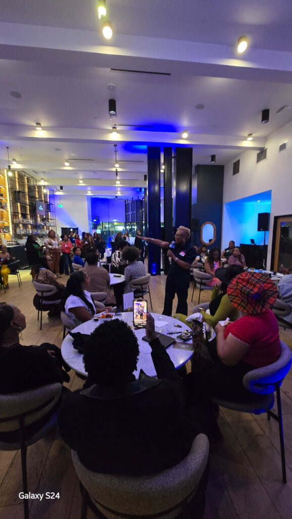 Lori A. Harris delivering the welcome address at 300 Strong, hosted by The Gathering Spot—an empowering moment of connection, purpose, and possibility.